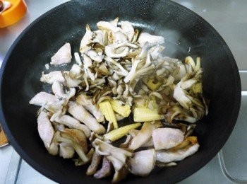 step3: 爆香後，下松阪豬炒熟，接著下玉米筍與舞菇