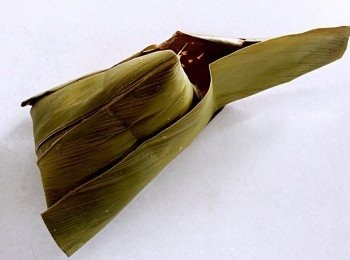 step5: 月桃葉在覆蓋上去兩邊葉子再貼粽身向月桃葉向下凹入折起