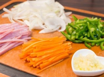 step1: 首先煮滾一大鍋水。
把洋蔥、火腿、甘筍和青椒切絲。蒜頭壓成蓉備用。
水滾後加少許鹽，下意粉，按包裝指示的時間減去 2 分鐘煮熟意粉。