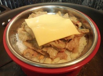 step10: 打開鑊蓋, 將易潔鑊中餘下的豬頸肉及汁料全部倒進白米上, 最後放上一片車打奶酪, 蓋回鑊蓋繼續蒸多 5-8 分鐘