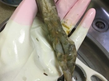 step2: 準備剪刀, 先將蝦腳及鬚剪走, 再將蝦背垂直放於掌心中, 用手握著蝦頭, 另一手用剪刀由蝦尾部份中間開始剪開, 保持兩邊相對的, 最後挑腸平放蝦