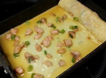 step9: 用筷子將蛋慢慢卷起,再將卷好的蛋推向鑊最前方向,再加入一殼蛋漿及魚柳,重複此動作