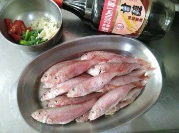 step1: 將紅魚【澎湖野生水產】從袋中取出，解凍，將去魚鱗、魚鰓、內臟，並清洗乾淨再於魚背畫刀，辣椒斜切、薑絲切絲、青蔥切段、蒜頭切塊，放於蒸盤上；