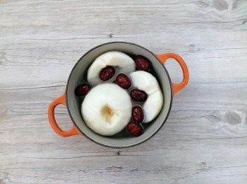 step2: 準備一個可放入電鍋內蒸煮的鍋或可蒸煮的容器(圖中是使用16cm的鑄鐵鍋),可將水梨切半或整顆放入鍋裡,注入約7分滿的水量,再放入紅棗。