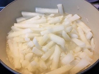 step3: 跟住放薑片落鍋爆香，然後落蘿蔔絲同條，倒入250ml 既水或者蘿蔔水，再加片糖同少許胡椒粉，滾後加蓋以細火煮約20分鐘