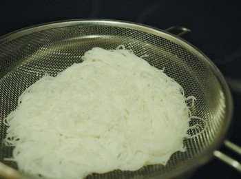 step2: 先將米粉用溫水浸軟身，然後放入沸水內煮數分鐘，撈起，瀝乾水份備用（也可用粉絲）