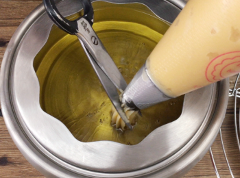 step7: 油熱後，擠出想要的長度，用廚房剪刀剪斷麵糊。