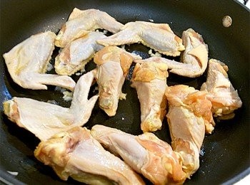 step2: 熱鍋爆香蒜頭，將雞翅表面朝下煎至金黃色。