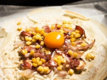step7: 於可放入焗爐之平碟或焗盤上鋪上餅皮，上面鋪上芝士碎﹑煙內﹑洋蔥﹑甜薯﹑粟米，中間打入一隻雞蛋，加上鹽和黑椒調味