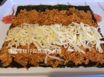 step8: 準備3片紫菜，將泡菜炒飯鋪在紫菜上，把50g芝士放在中間然後卷實，重複包完其餘的紫菜、炒飯和芝士。