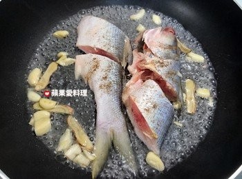 step5: 魚肉半熟時（紅紅的鮮魚，有一半轉成白色時，就是半熟），淋入米酒，放半碗水，蓋鍋蓋燜煮。
