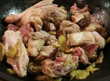 step5: . 當薑味出來後，色澤轉成金黃色時，加入鴨塊和香菇以中火拌炒。