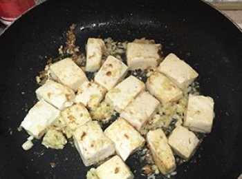 step3: 豆腐切塊，鍋內加入少許油後放入豆腐略煎，再加入薑末爆香。