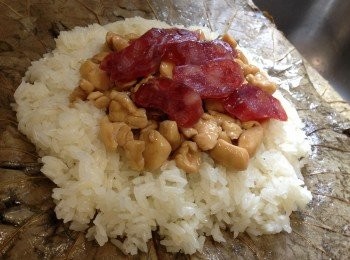 step4: -用小許油起鑊，炒熟雞柳，下芡汁，用生粉水埋芡，記緊芡要較杰，要有點似漿糊狀，否則包餡時糯米會浸濕，所以生粉水要一路煮一路加至杰，盛起被用。

-  在瀝乾的荷葉上薄薄的掃小許油，放一層糯米飯，舖上雞粒芡 (先舖好雞粒，再在上倒放適量芡漿，如有多的可棄掉)，再舖上臘腸片，