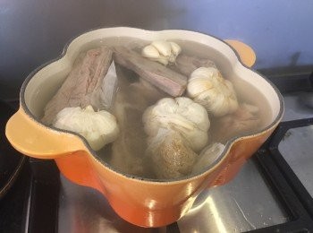 step2: 2. 準備一個煲，煲水，水滾後放入湯包、豬骨同蒜頭