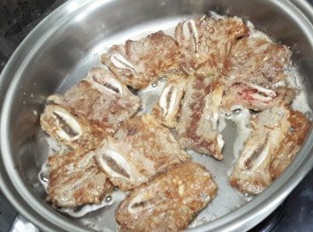 step2: 熱鍋下油，煎牛仔骨至兩面金黃色，盛起備用