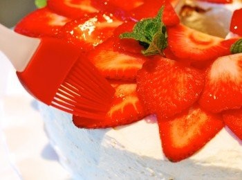 step13: 將鮮奶油於蛋糕表面塗抹均勻，表面鋪上草莓片，刷上少許龍舌蘭糖漿，以薄荷葉裝飾即可