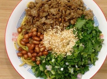 step6: 拌好的乾麵上面依次鋪上蔥、芫茜、豬肉、炸花生，中間放入熟芝麻和炸蒜