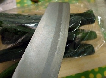 step3: 取一個塑膠袋，裝入小黃瓜後，用刀輕拍裂小黃瓜。 再用刀背將小黃瓜切段，放入少許鹽搓揉均勻，靜置五分鐘，再將出水倒出備用。