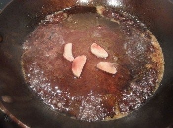 step9: 利用煎完牛排的鍋子,倒入醃製牛肉剩下的紅酒醬汁煮滾,將鍋底的精華融化,煮至酒精揮發留下酒香。煮至呈現濃稠醬汁即可,取出蒜片不用。
