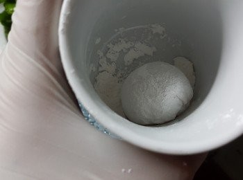 step12: 當包好餡後,用杯裝上已經炒熟的20g糯米粉,將糯米糍放入杯內不停轉圈,待糯米糍沾滿糕粉即可(入杯轉圈作用是令糯米糍更圓)