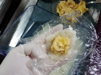 step10: 戴上手套,取出一份粉糰用手按扁,中間放上適量榴槤肉,然後包上及埋口