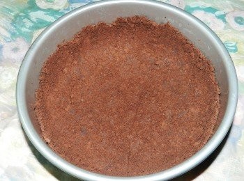 step1: 巧克力夾心餅裝入塑膠袋中，用橄麵棍壓一壓、打一打，然後鋪入八吋可分離蛋糕模中，壓實(底與1/2模高)