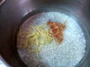 step2: 白米洗淨加入二倍的水 , 加一茶匙沙拉油 ; 干貝先洗淨再用米酒和開水浸泡 ;  把薑絲或薑片和瀝乾水的干貝加入米中 ; 放到電鍋中 ; 外鍋加入二杯水