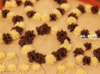 step9: 接著以交錯的方式在烘焙紙上擠出雙色麵糊，繞成一個個花圈狀。