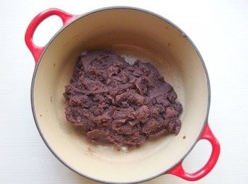 step7: 準備一個炒鍋,將玄米油倒入加熱,再將豆沙倒入拌炒一下。 加入砂糖及麥芽糖一起拌炒,豆沙遇到砂糖會變得水水的,經過一段時間翻炒...水份慢慢會收乾,直到豆沙變成糰狀即可。（如果豆沙份量多的話,大約需花上30分鐘以上的時間翻炒）