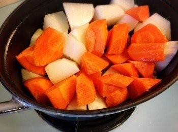 step4: 一小時後，加入用滾刀方式切好的甘荀及白蘿蔔，再炆一小時至入味即成。