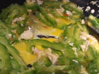 step6: 爆香香料後下苦瓜片, 再將咸蛋白和苦瓜炒混加少許糖, 之後再下蛋液待蛋液稍為凝固再炒混即成。