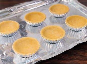 step18: 組合及烤焗做法：把批皮麵糰分成 3:2 之比例，較大的一份再分成 6 等份，每份略搓圓。把一份麵糰放入撻模，先按好底部，再由中間底部往外按，按至批皮平均鋪滿撻模成批底。（可參考 http://www.youtube.com/watch?v=eqATOS7f-BQ）