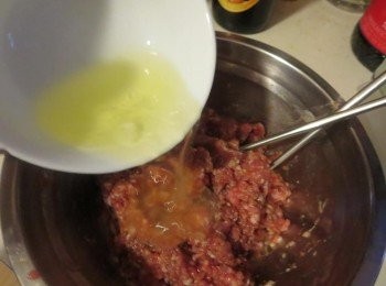 step2: 加入一半的蛋白，蛋白和肉醬出現分離現象是正常的，所以稍為拌勻即可，加入粟粉，攪拌，材料便會自然融合，再加入餘下的蛋白，稍為攪拌，加入麵粉，最後加入一湯匙水，攪拌約 1 分鐘，肉醬會愈攪愈有黏性，攪拌好的肉醬不會黏在碗邊，很容易用刮刀推成一糰