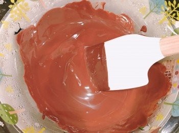 step1: 先在小煲煮滾熱水。熄火後，隔著熱水座溶朱古力，加入切成小粒的牛油拌勻。