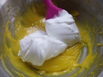 step4: 預備一個乾淨冇油冇水既大碗，蛋白利用電動打蛋器打起，先打約30秒，加入65g砂糖繼續打，直至蛋白完全打起

 取部分蛋白糊倒落蛋黃糊中， 利用fold  in方法(由下刮向上)拌勻