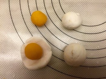 step7: 奶黃湯圓：將奶黃餡自冰箱取出，均分成1個10克，搓圓，包入6的糯米糰中，再收口搓圓就是奶黃湯圓