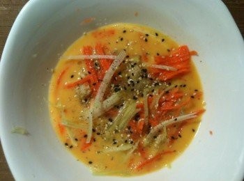 step3: 【調製蛋液】：將刨絲紅蘿蔔、刨絲西洋芹、切塊鹹酥雞加入蛋液，再灑上黑胡椒、白胡椒、義大利香料、鹽、糖、黑芝麻和白芝麻，蛋液就調好了。