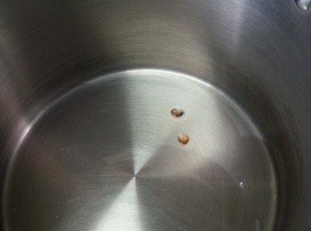 step2: 將菜油用中火煮熱,放兩粒粟米粒入油中試油溫