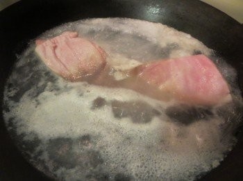 step1: 猪肉先用针插一遍，準備一鍋熱水, 放入已洗淨之五花腩, 加入紹酒, 煮約15-20分鐘至6-7成熟, 取出過冷水. 用刀刮干净毛後, 再沖洗乾淨, 用廚用紙抹乾水份