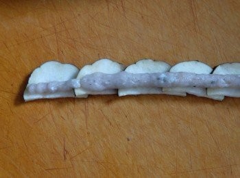 step3: 在茄子半圓的底部擠上一條長長的鯪魚肉，然後捲起來成玫瑰花形狀。