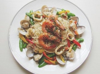 step8: 將義大利麵裝盤後,放入剛才完成的鮮蝦和中捲,這樣的做法可讓鮮蝦及中捲的焦香保留住,利用蛤蜊鮮美的海味及鮮蝦留下的焦香鍋底精華來做成醬汁,一道義大利麵可吃到兩種不同料理手法的口感及香氣