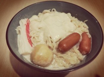 step3: 把牛奶倒入煲內，煮沸後，下芝心腸、魚蛋、蟹柳和泡麵。