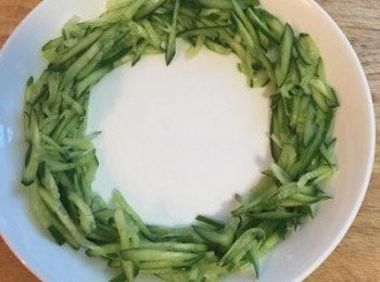 step6: 冰鎮後的小黃瓜絲鋪在盤子的週圍，中間放入炒好的肉絲，再擺上瀝乾的蔥絲，即完成好吃又下飯的醬爆肉絲喔～