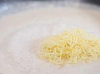 step5: 加入雞湯、忌廉，轉中火煮至滾起後加入巴馬臣芝士碎，煮至醬汁濃稠。