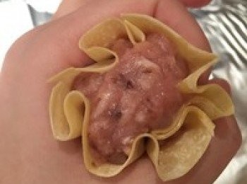 step3: 取一张云吞皮，用厨房剪把正方形四角分别剪去。
注意不要剪太多，剪好成为一个八边形，这样包好的烧卖可以把内馅露出。
用虎口把烧卖拢成小袋子形状，不要收口，露出内馅。