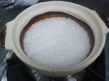 step2: 瓦煲內塗一層食用油，倒入已浸的米及水，蓋上蓋，用中大火煮約12分鐘，至水收乾