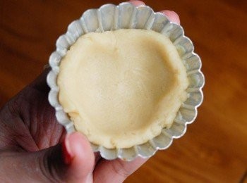 step3: 在撻模內塗一層薄薄的牛油。將麵糰分成9-10份，將一份麵糰搓圓，放在模具內，再用手指將麵糰壓扁，令麵糰平均地鋪在模具內