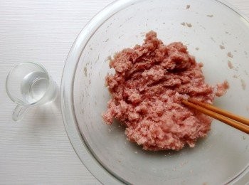 step4: 進行絞肉[打水]:將鹽加入水中,再用一雙或二雙筷子以同一方向,邊加一點水邊攪拌(同一方向),將水慢慢打入絞肉裡,打水時所添加的水量需隨時觀察,冷藏後的絞肉較吸水,打水之後的絞肉會變得比原先更加蓬鬆且具有黏性。