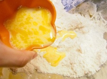 step4: 將餘下的奶加入蛋黃，再注入麵粉混合物中。